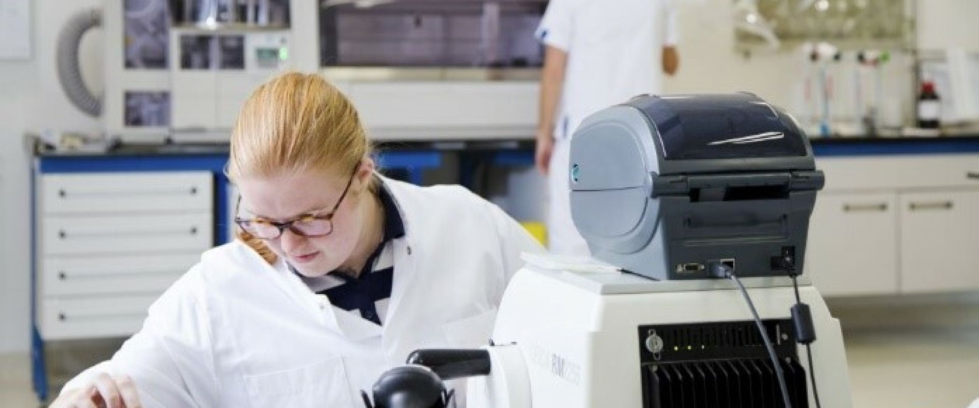 Patholoog analyseert weefsels en cellen achter geavanceerde machines.