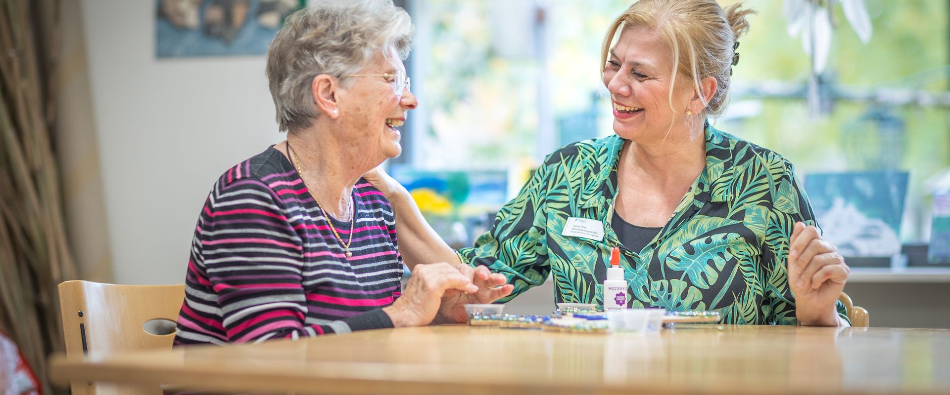 Medewerker en clIënt doen activiteit aan tafel