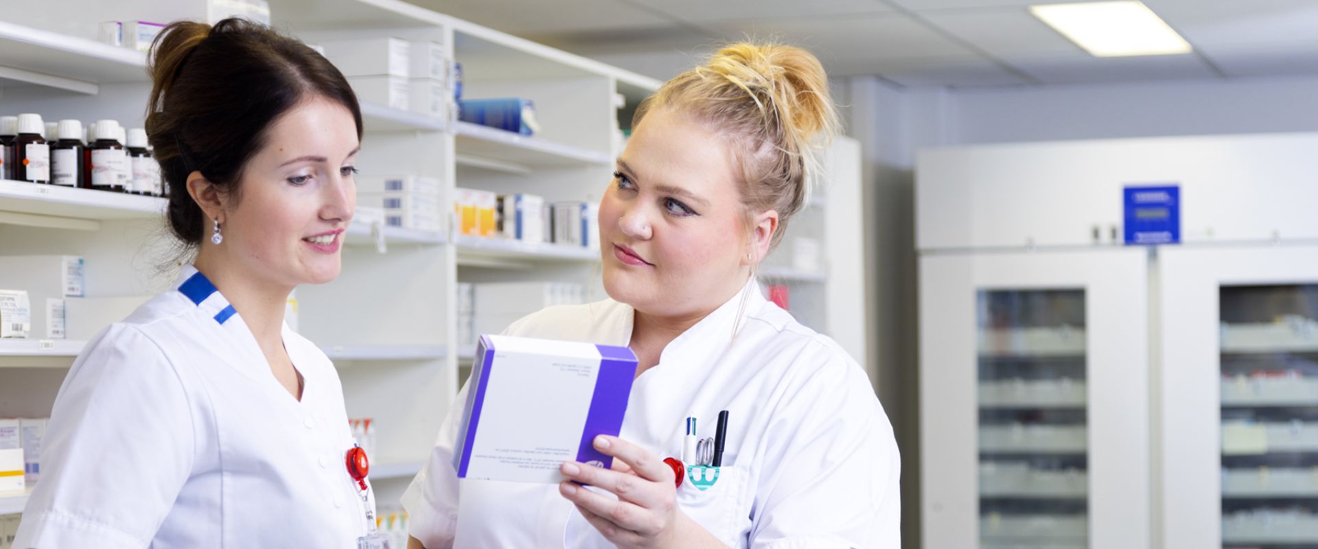 Twee medewerkers van de ziekenhuisapotheek bespreken de medicijnen met elkaar. 