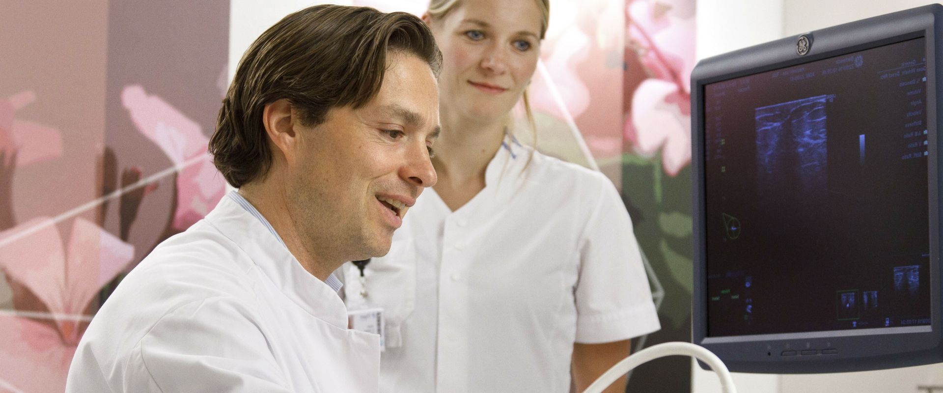 Verpleegkundige en arts van het Mammacentrum bekijken samen resultaten