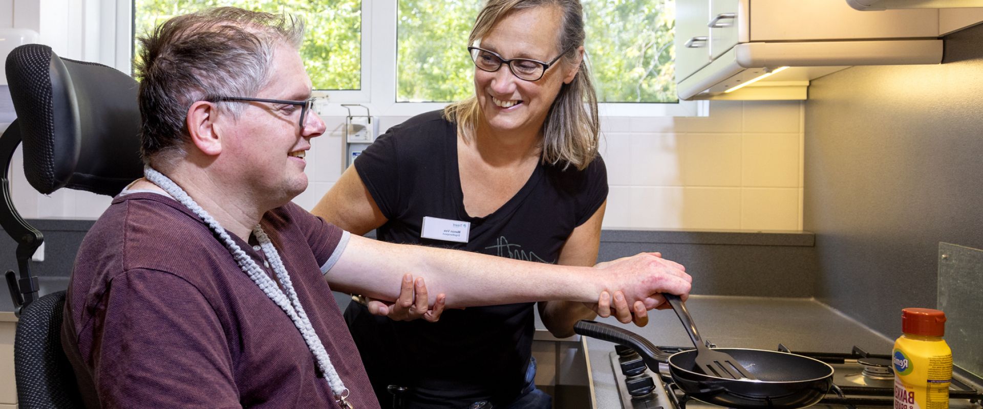 Ergotherapeut helpt cliënt met eitje bakken