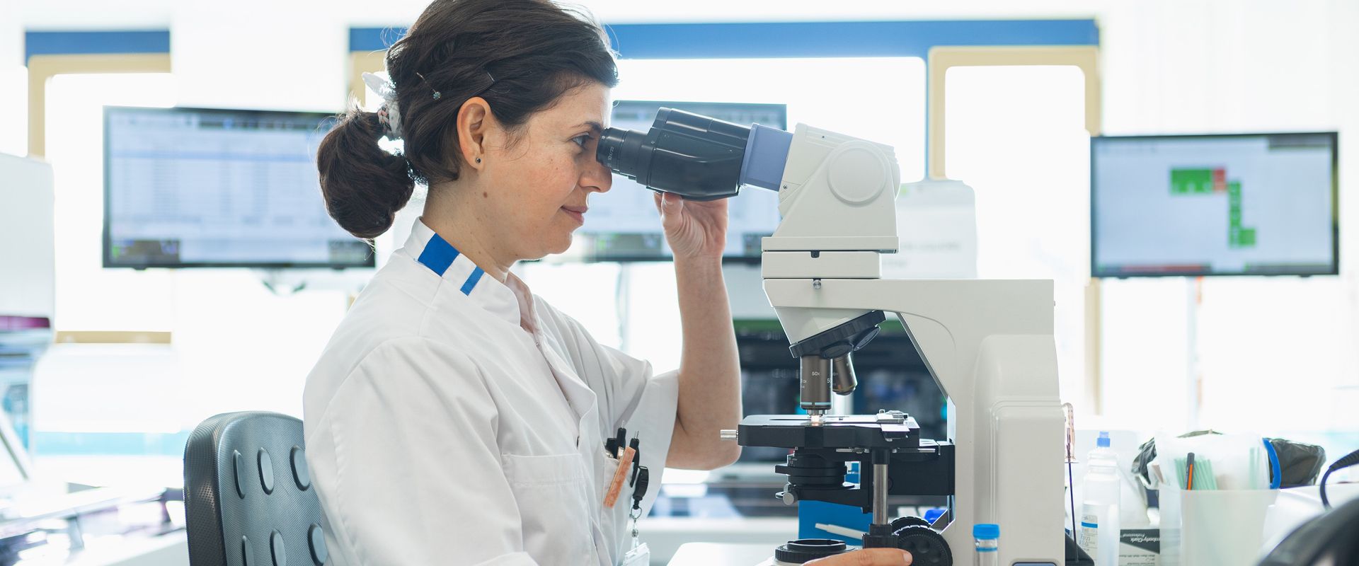 Labonderzoek medewerkster achter de microscoop.