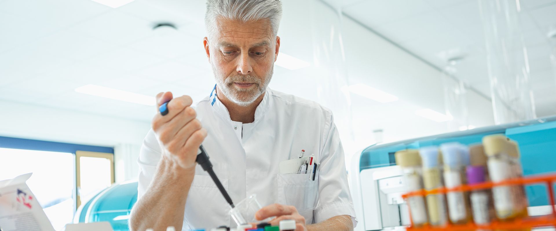 KCL medewerker doet onderzoek met buisjes