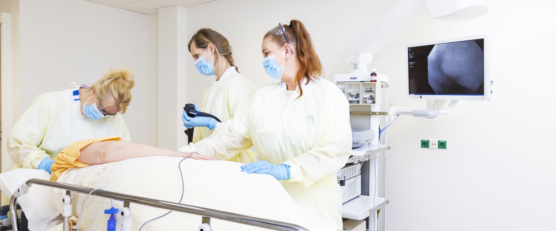 Zorgprofessionals maken patiënt klaar voor een endoscopie.