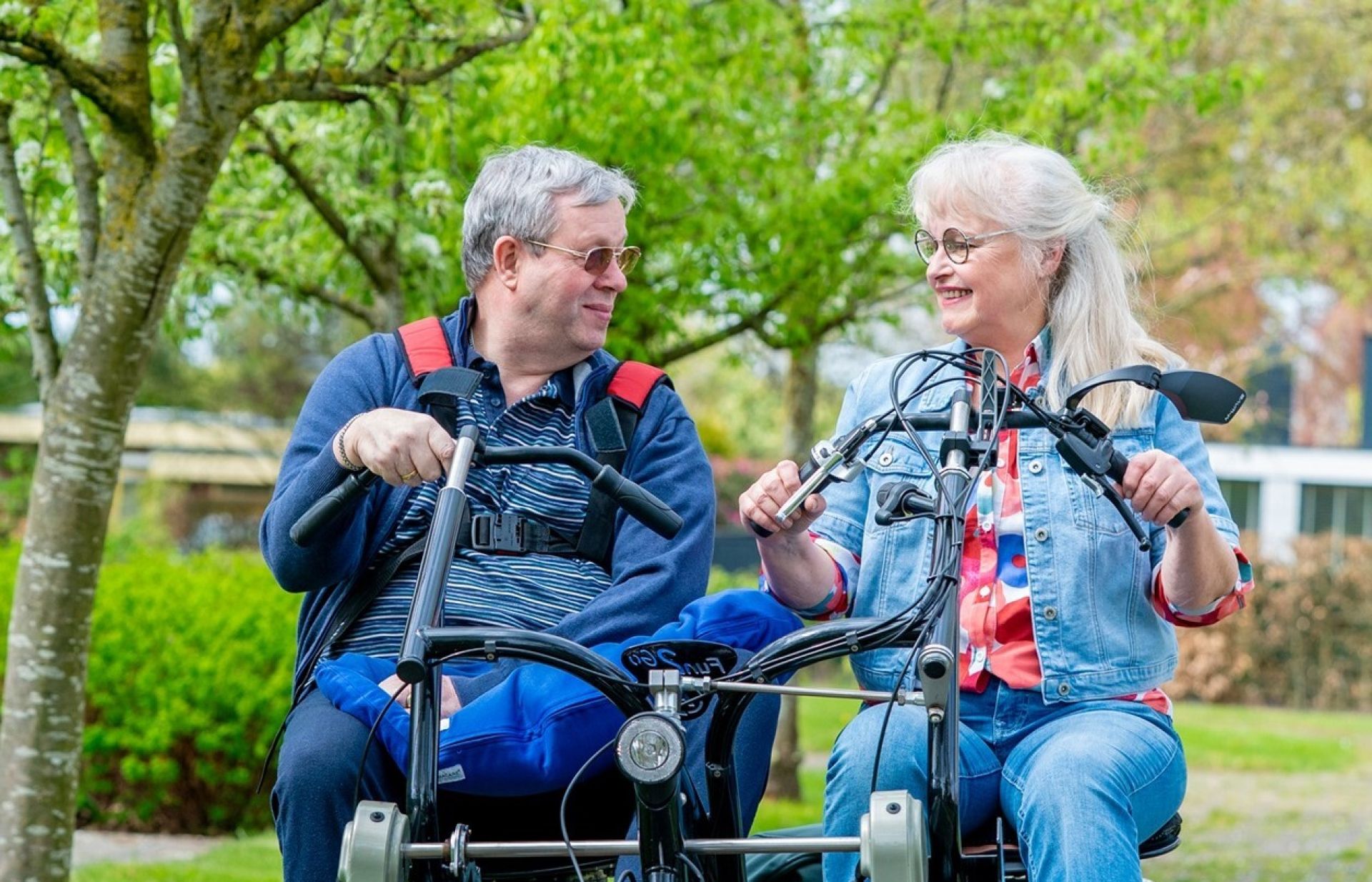 Meneer en mevrouw fietsten samen op een duofiets door een park.