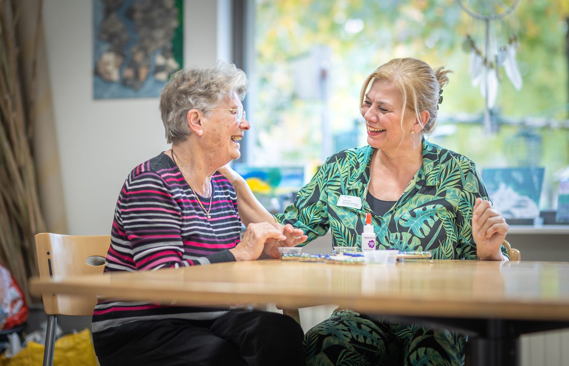 Medewerker en clIënt doen activiteit aan tafel