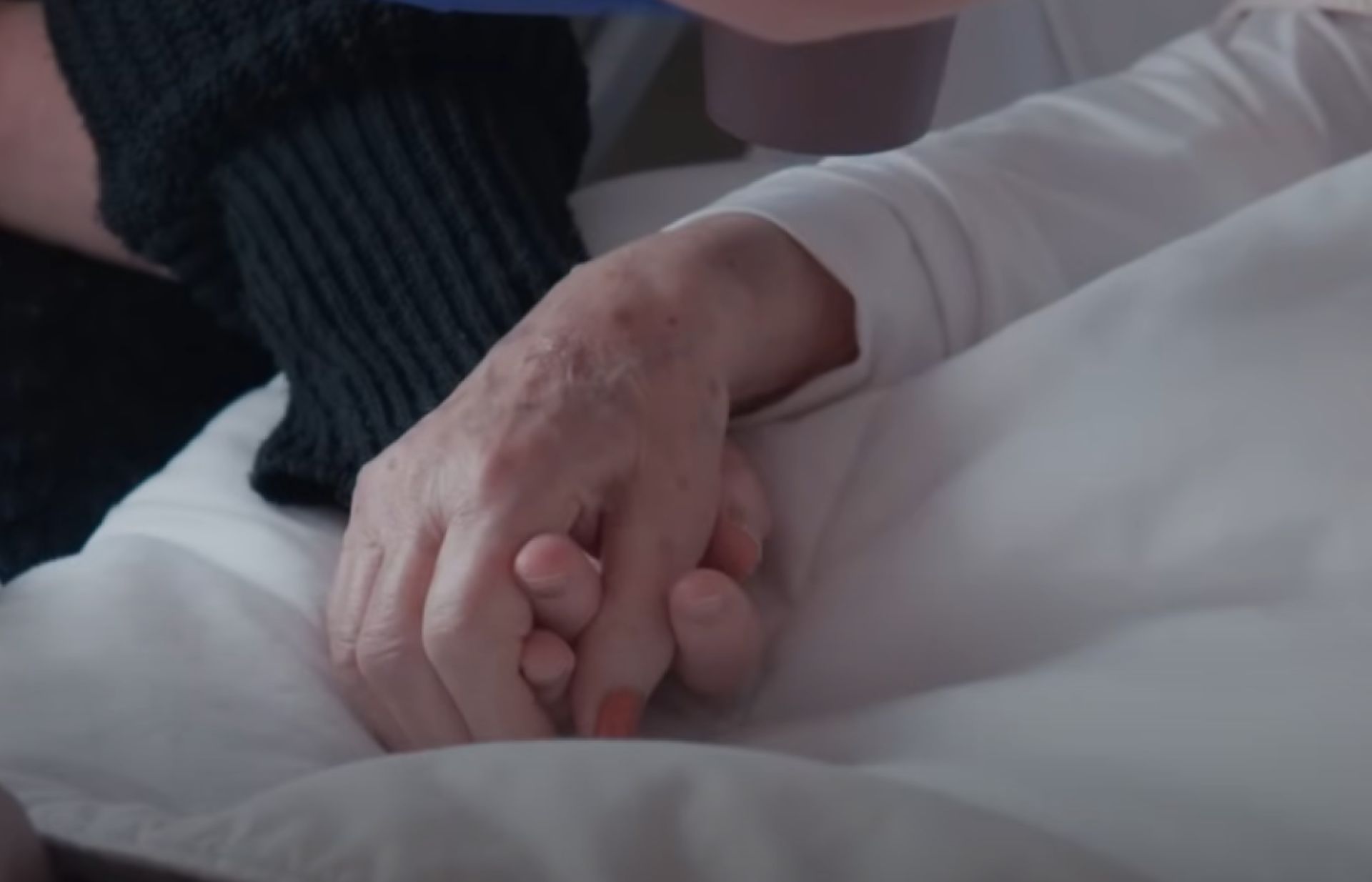 Vrouwen houden elkaars hand vast. 