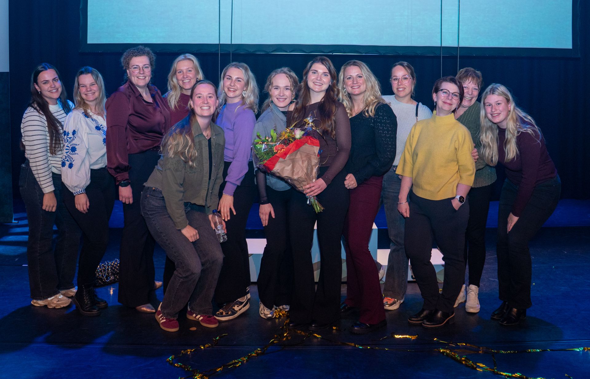 Collega's op de foto met een bos bloemen in de hand