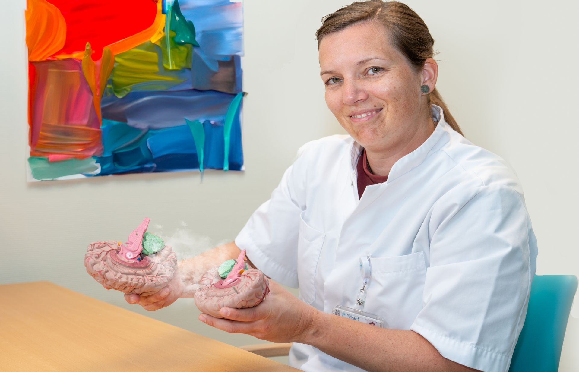 Arts Rianne Kofman zit aan bureau en glimlacht