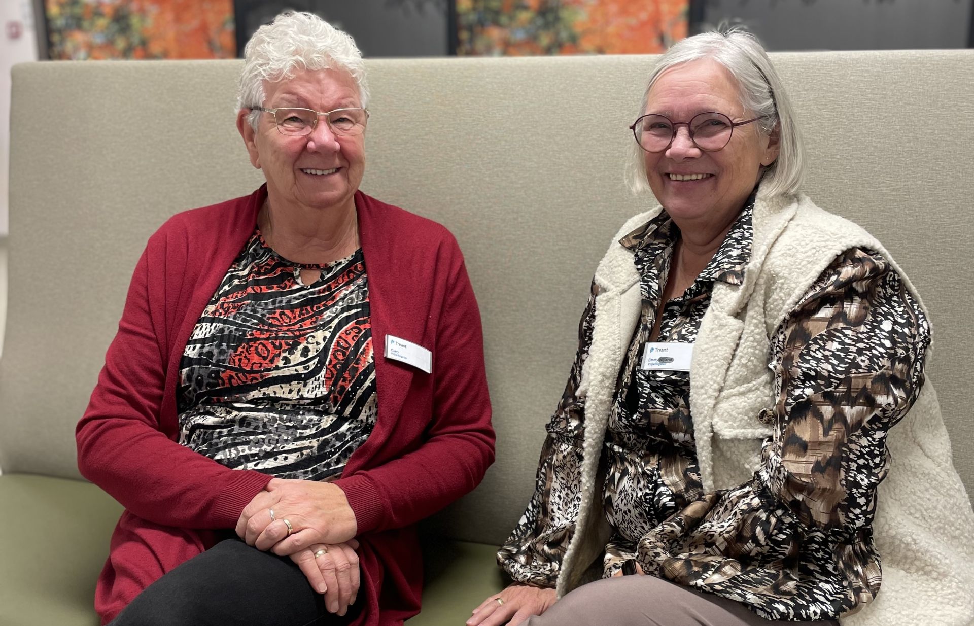 Vrijwilligers Clary en Emmy zitten naast elkaar op een bankje