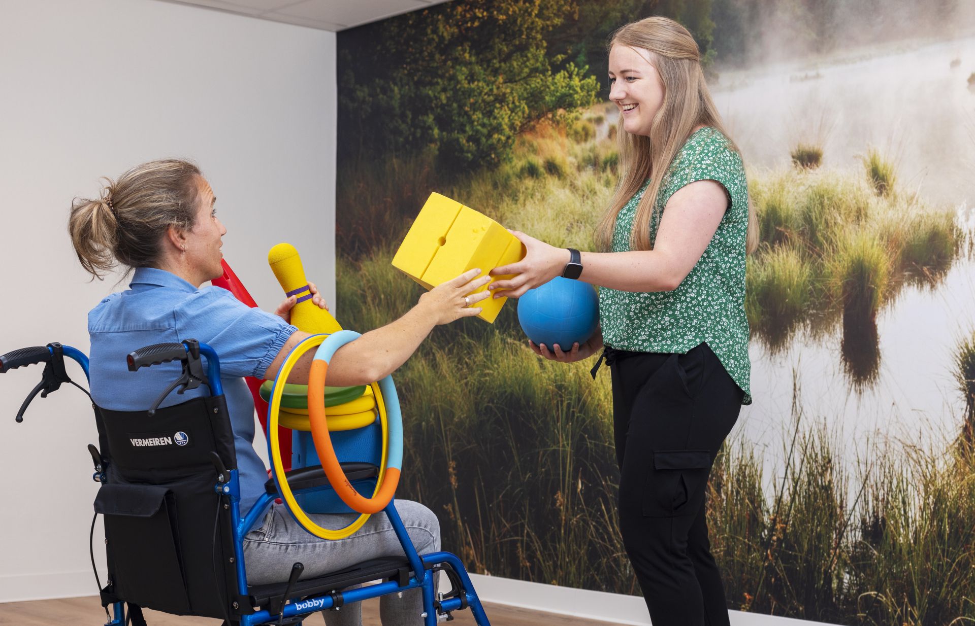 Cliënt in rolstoel doet sportactiviteit met therapeut