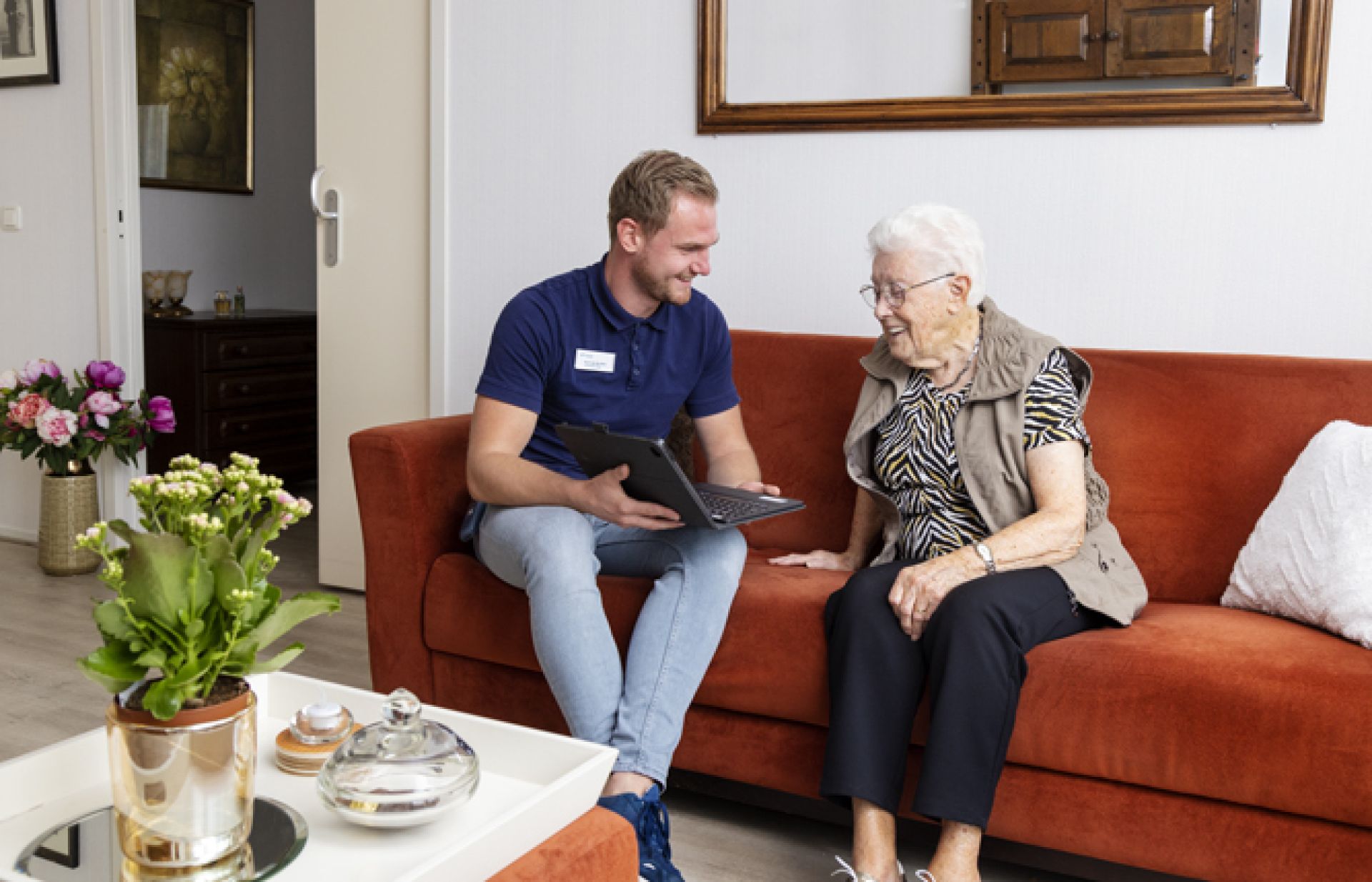 Bewoner van Holdert kijkt samen met een medewerker op de tablet