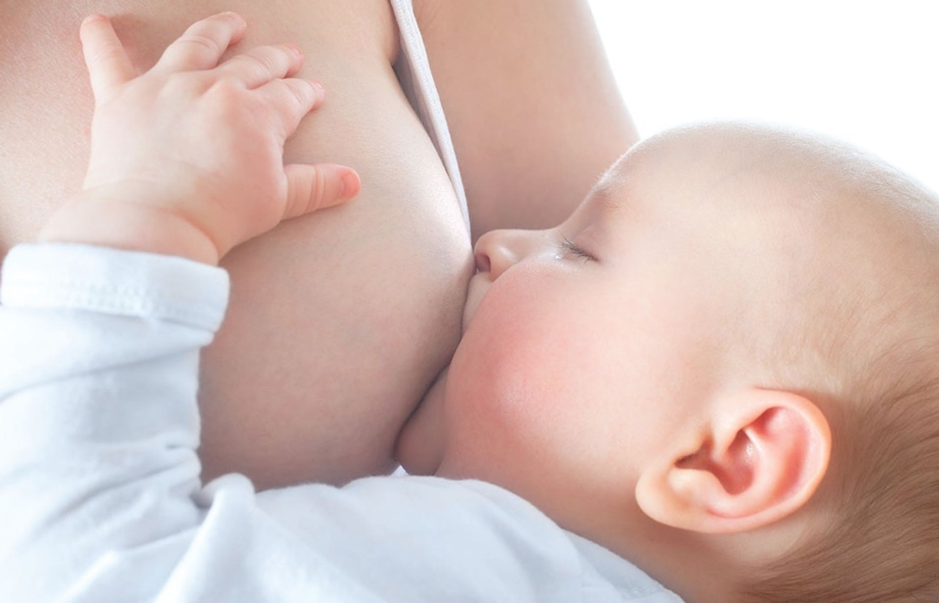 een baby die aan de borst ligt bij de moeder