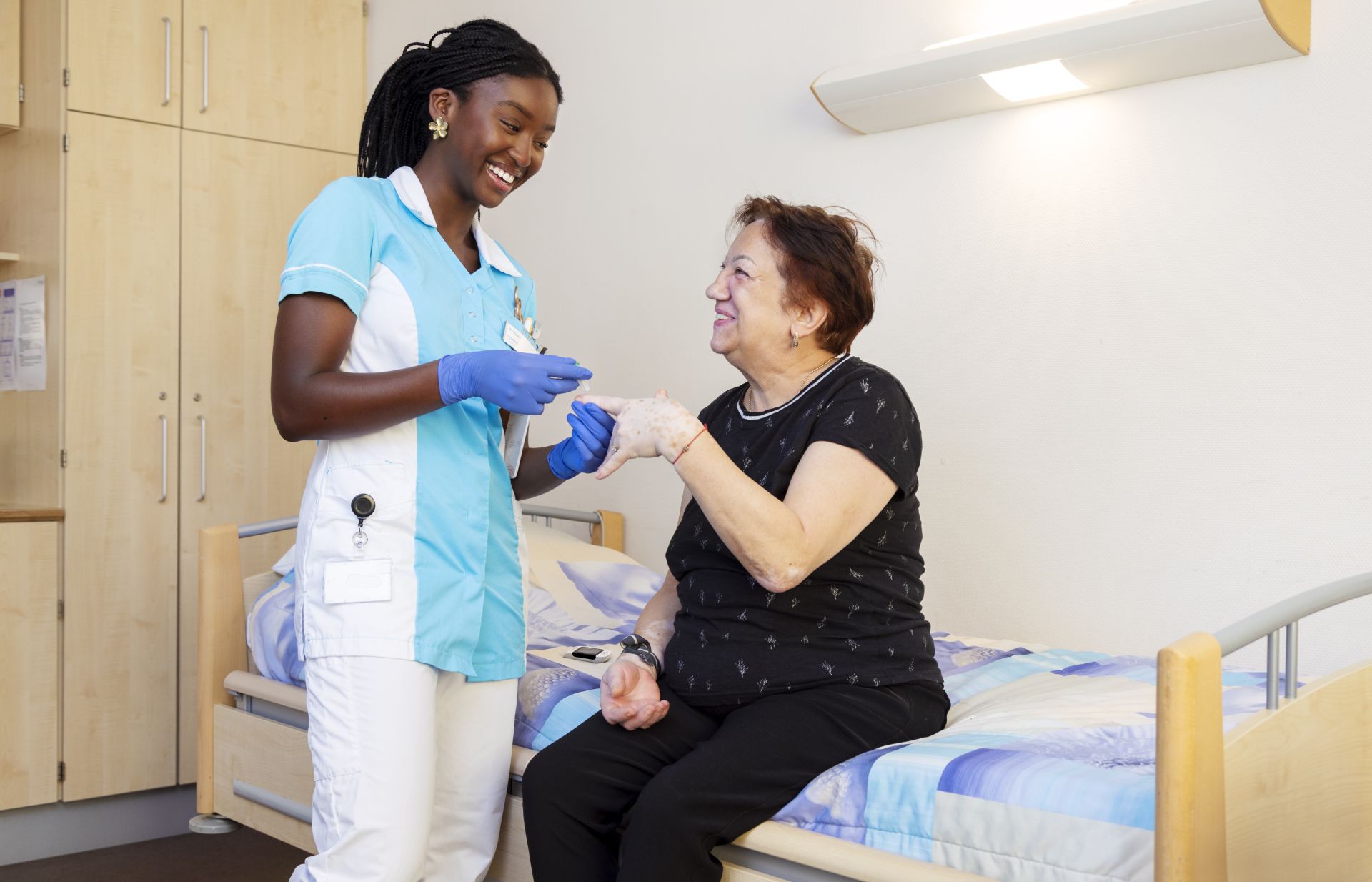 Stagiaire Chakira bloedsuiker meten bij Marja (clíënt)