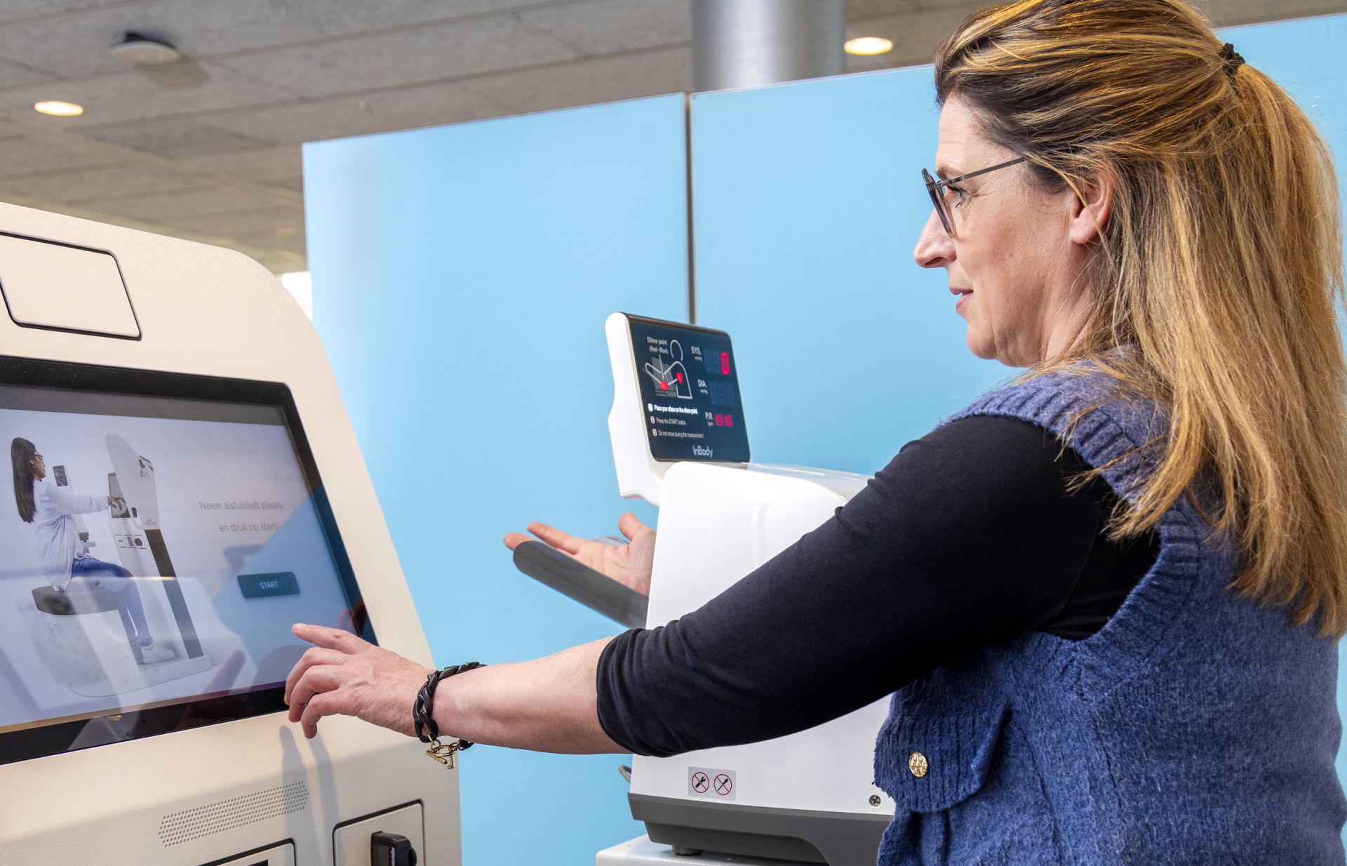 Vrouw gebruikt een gezondheidsapparaat met touchscreen.