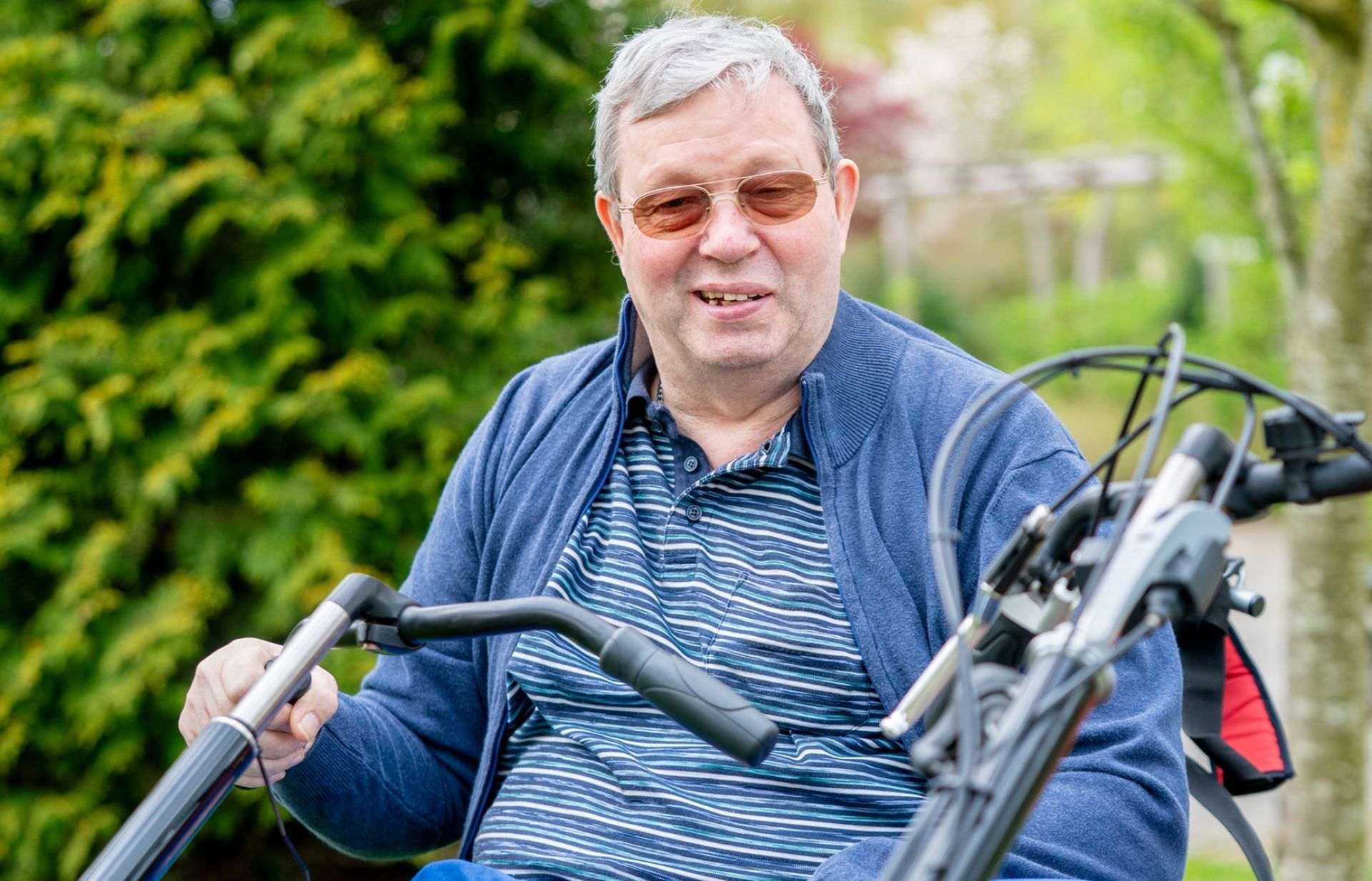 Een man op een driewieler geniet van een ritje buiten.