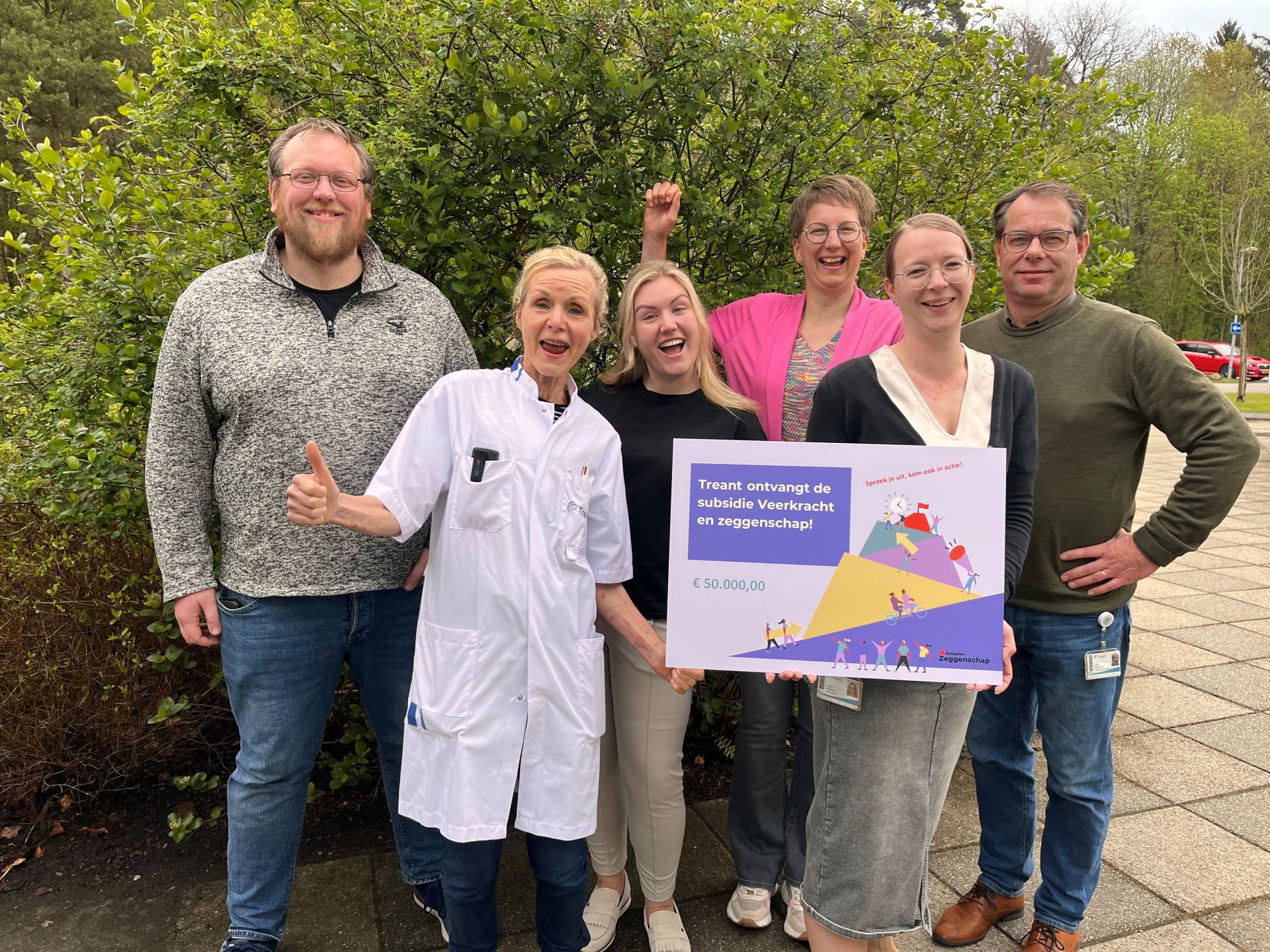 Blije collega's van Treant met in hun hand een cheque van de subsidie Veerkracht en zeggenschap