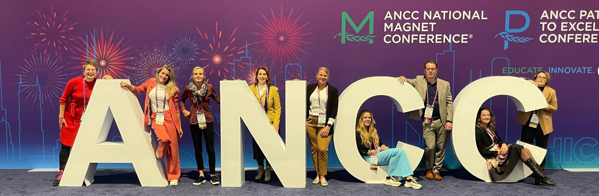 Foto met de verpleegkundigen die een bezoek brachten aan Amerika. Zij poseren bij grote letters ANCC.