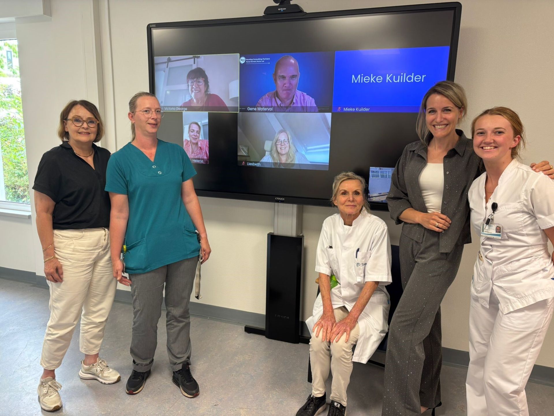Een groepsfoto van de magneet-betrokkenen van Treant met onder andee Vicky en Eugene op het scherm