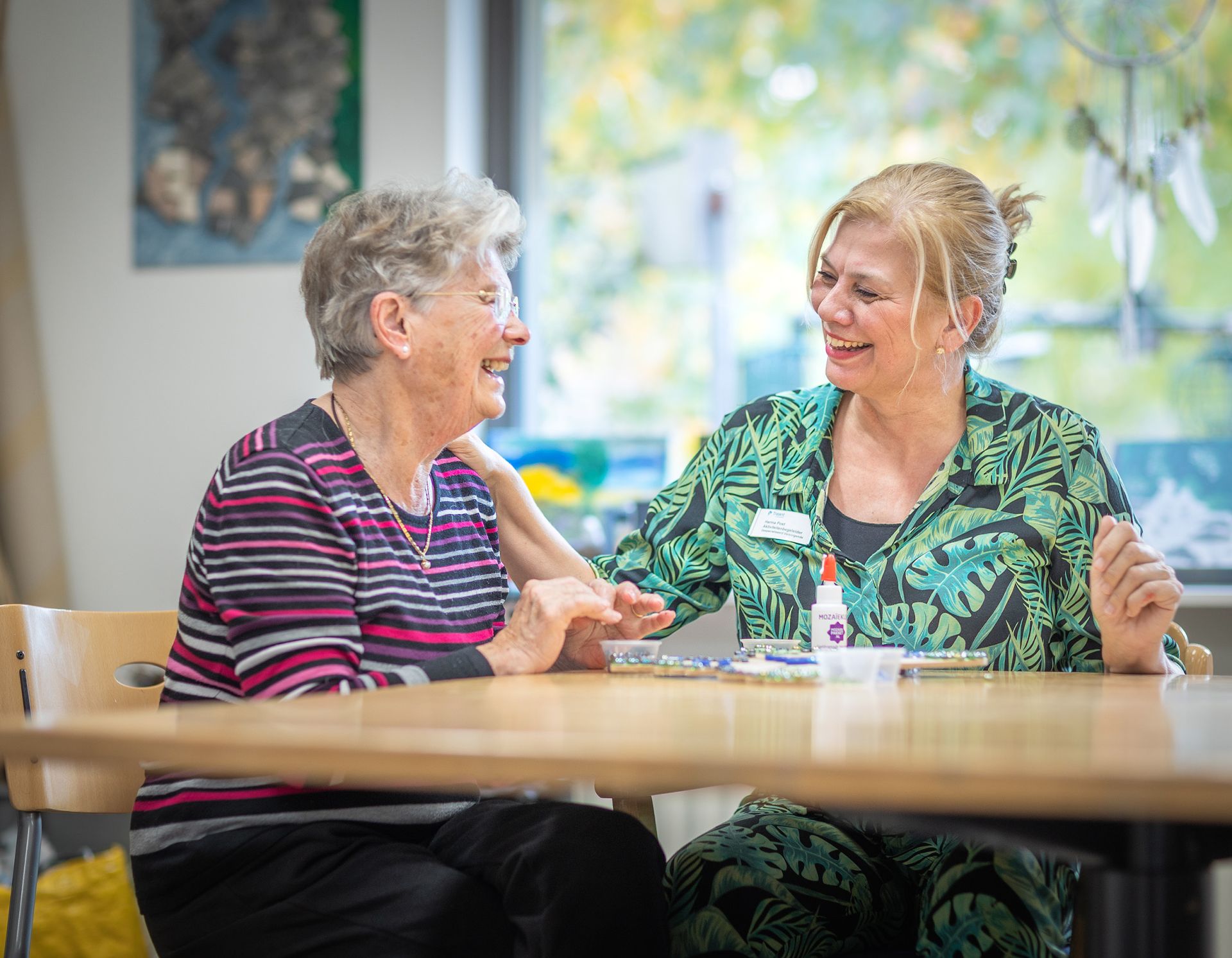 Medewerker en clIënt doen activiteit aan tafel