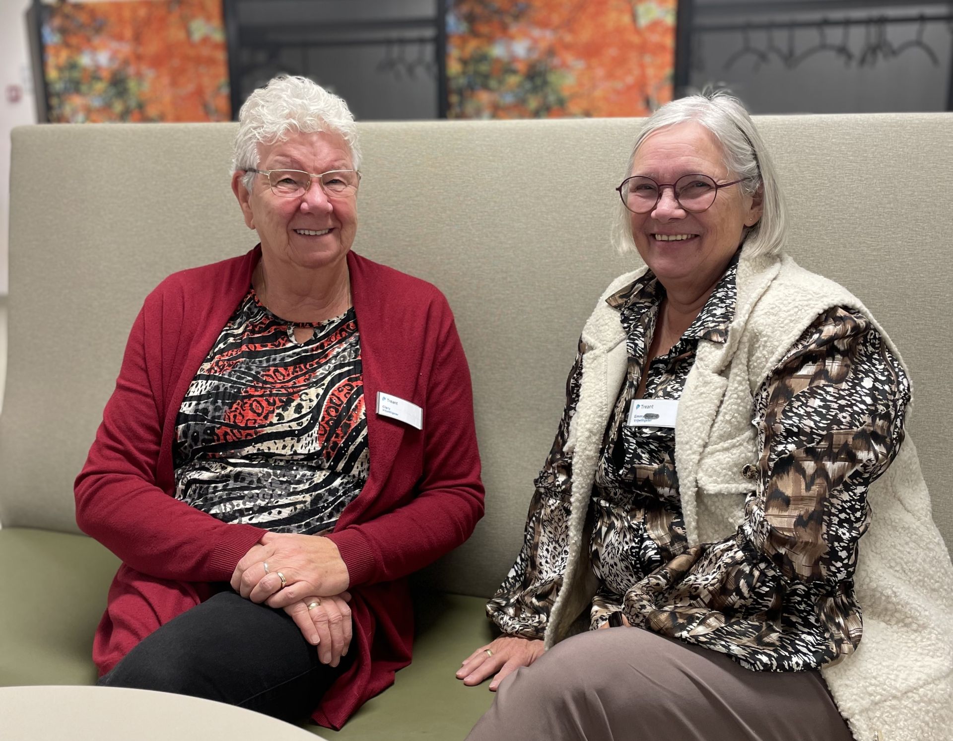 Vrijwilligers Clary en Emmy zitten naast elkaar op een bankje