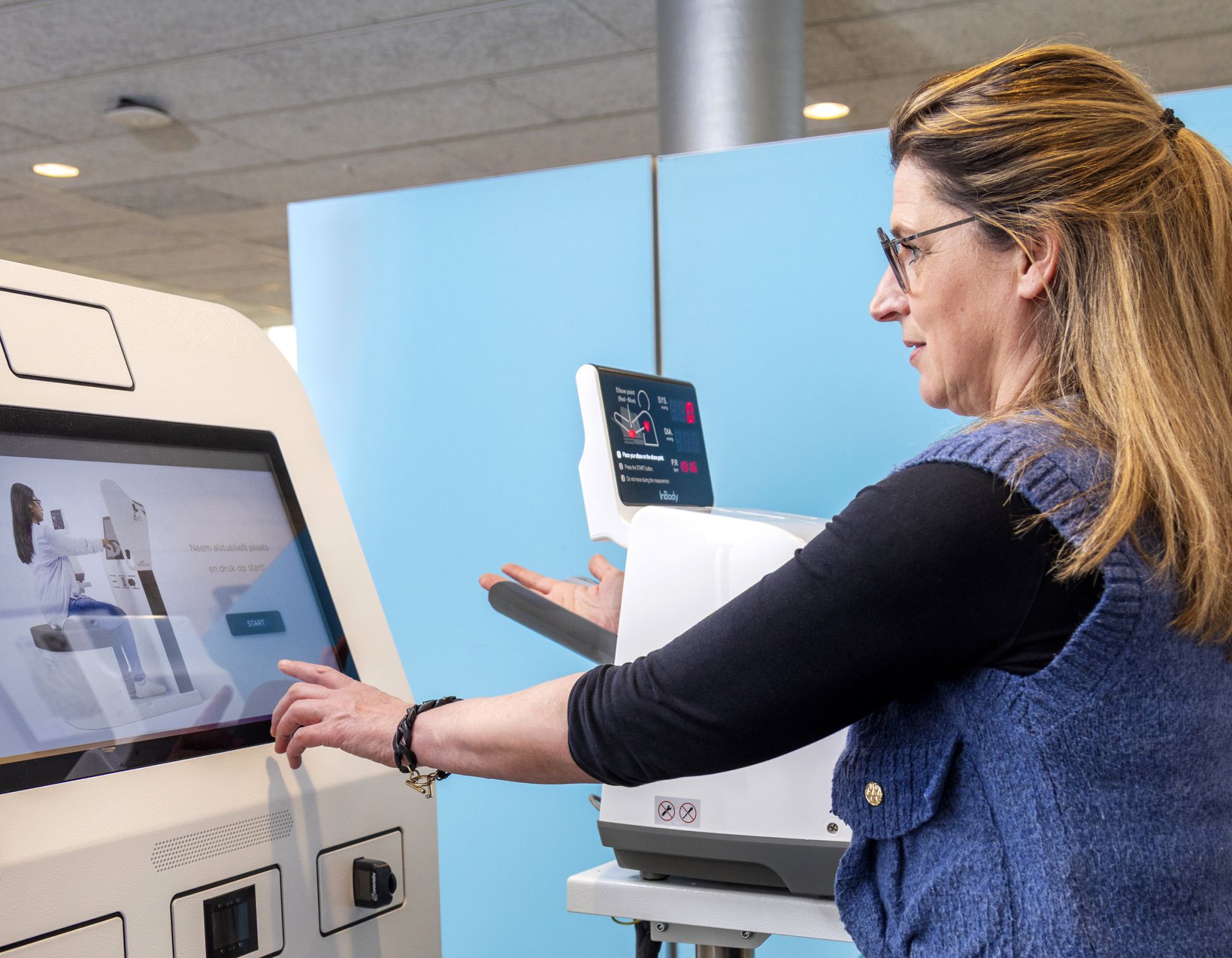 Vrouw gebruikt een gezondheidsapparaat met touchscreen.