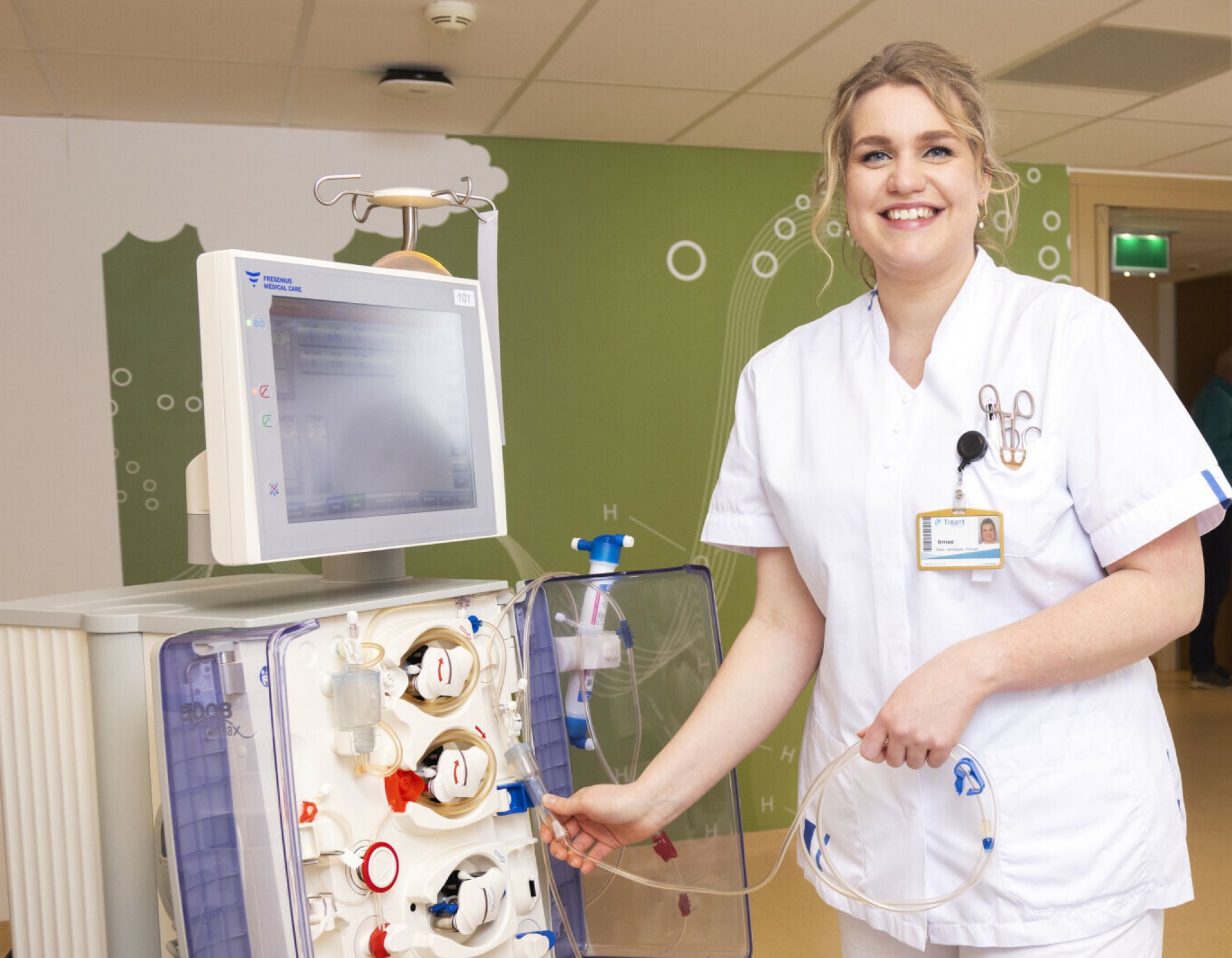 Dialyseverpleegkundige bij een dialysemachine