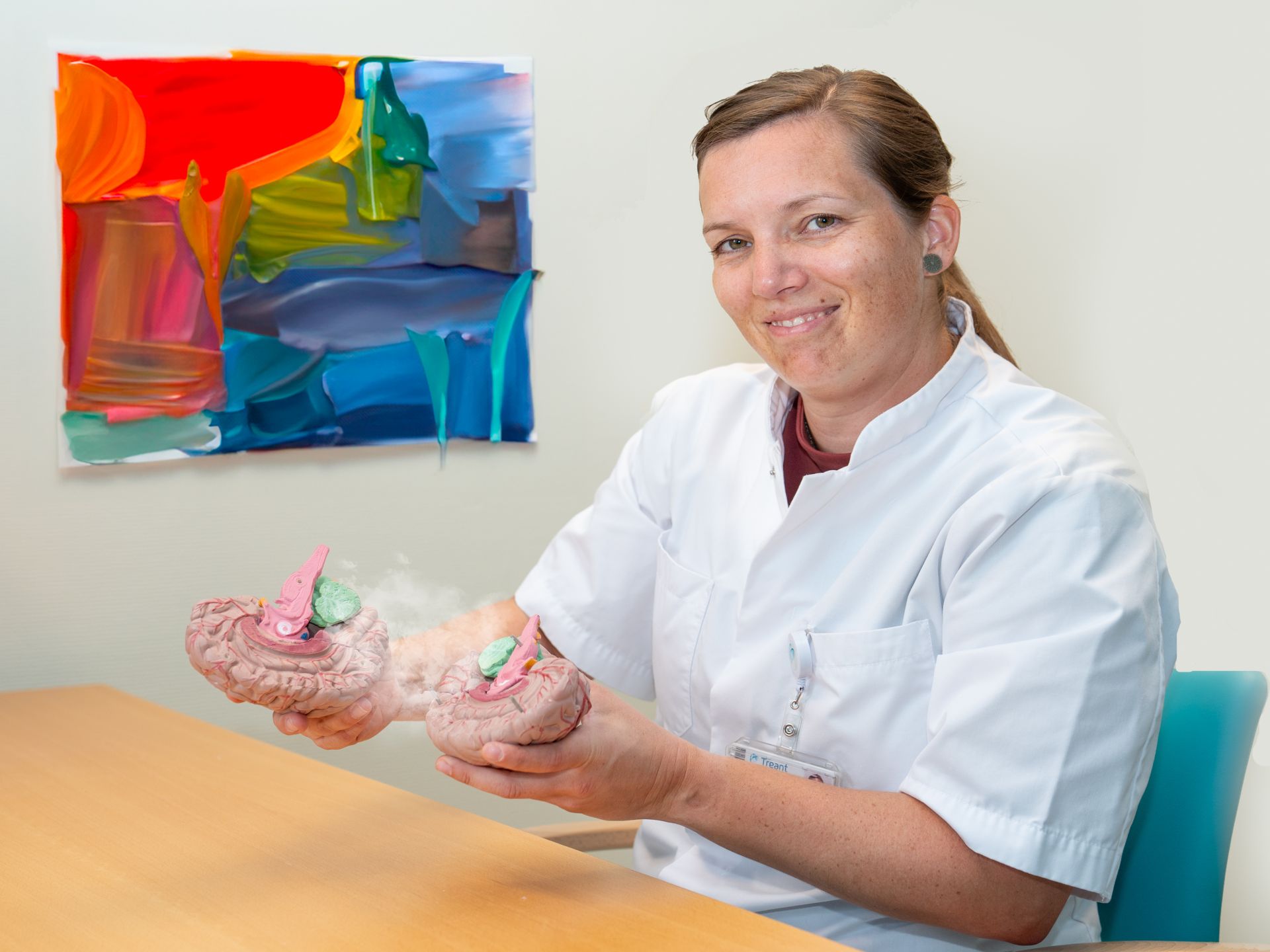 Arts Rianne Kofman zit aan bureau en glimlacht