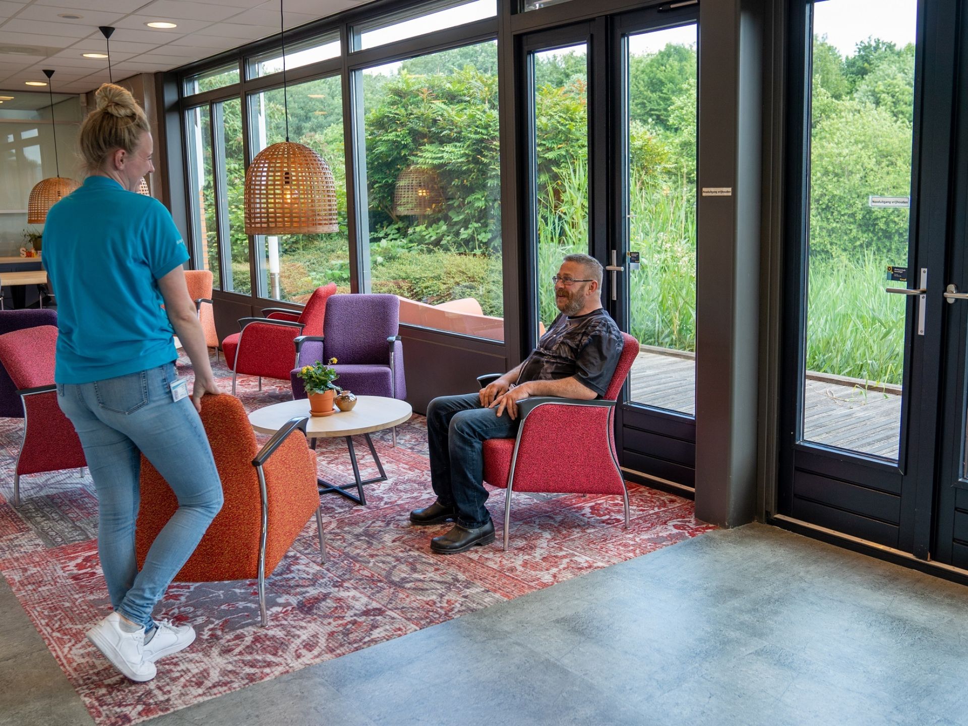 Medewerker van Treant en dialysepatiënt in gesprek in de ontvangstruimte