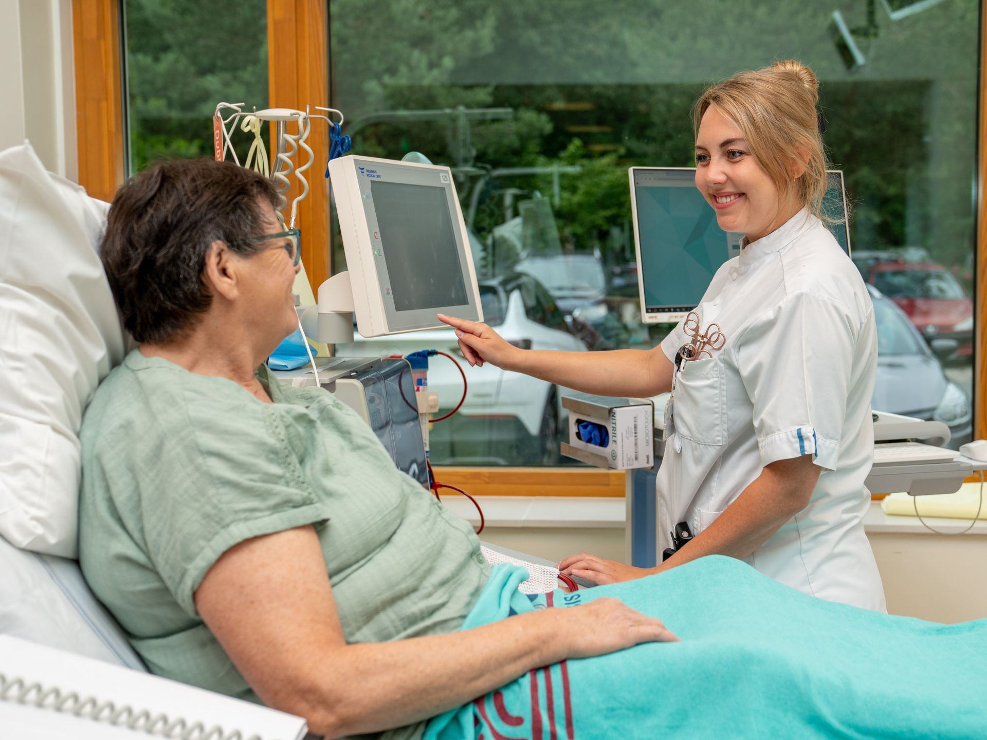Dialysepatiënt en medewerker met elkaar in gesprek