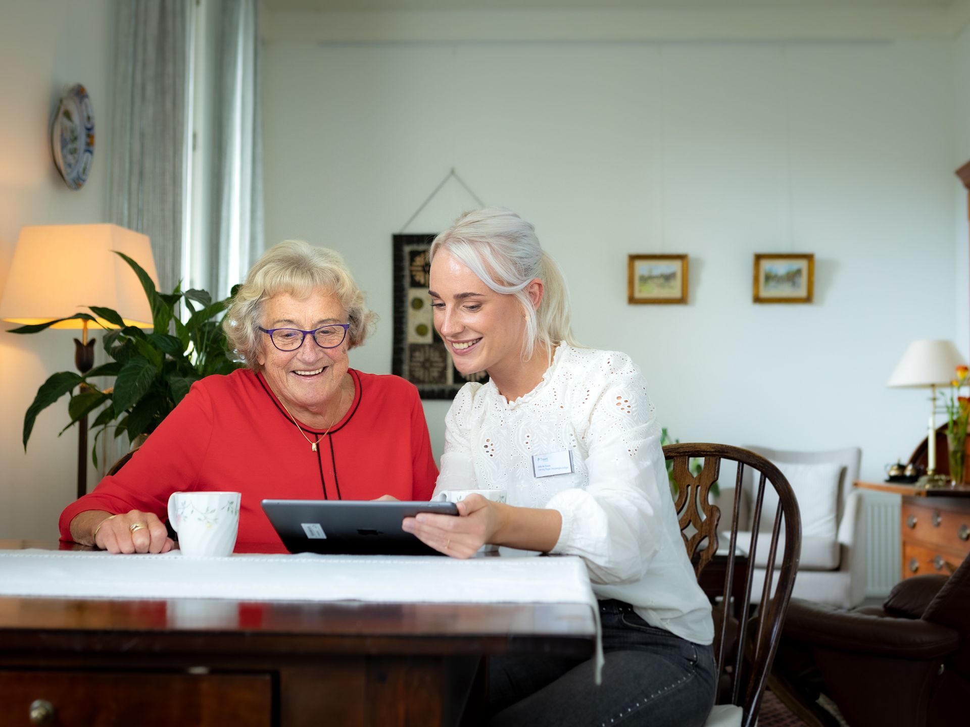 Zorgmedewerker en cliënt kijken samen op een tablet