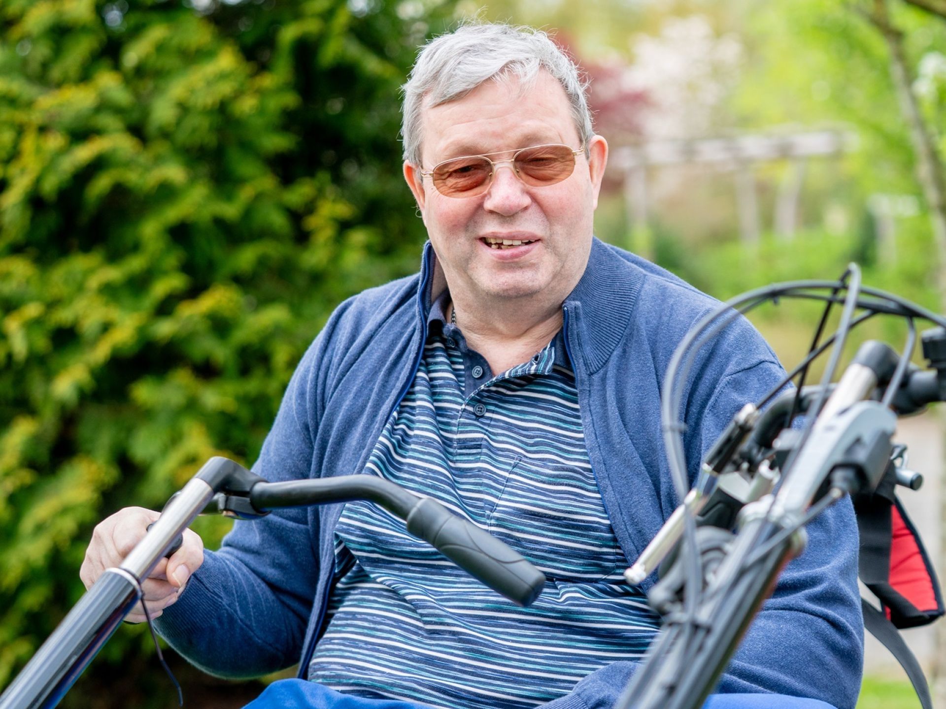 Een man op een driewieler geniet van een ritje buiten.